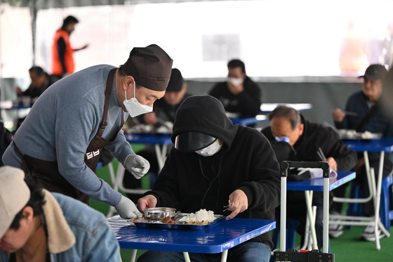 President-elect Yoon Suk-yeol does volunteer work serving free meals to the needy at a soup kitchen in the compound of Myeongdong Cathedral in central Seoul on Wednesday. [NEWS1]