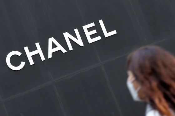 A passerby walks past a Chanel boutique. [NEWS1]