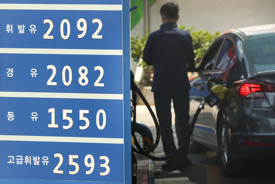 A driver fills up his car at a gas station in Seoul on Sunday. According to Korea National Oil Corp., the average price of a liter of gasoline is down 0.57 won compared to the last week of March to 1,993.97 won. The average price in Seoul dropped 2.25 won to 2,052.74 during the same period. As gasoline prices continue to remain high due to the war between Russia and Ukraine, the Korean government is currently looking into increasing the fuel tax cut from the current 20 percent to 30 percent. The temporary cut is set to expire at the end of July. [YONHAP] 