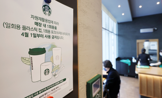 A poster at a Starbucks branch explains that disposable cups and plastic forks, spoons and knives are prohibited for customers eating or drinking in the branch starting April 1. [YONHAP]