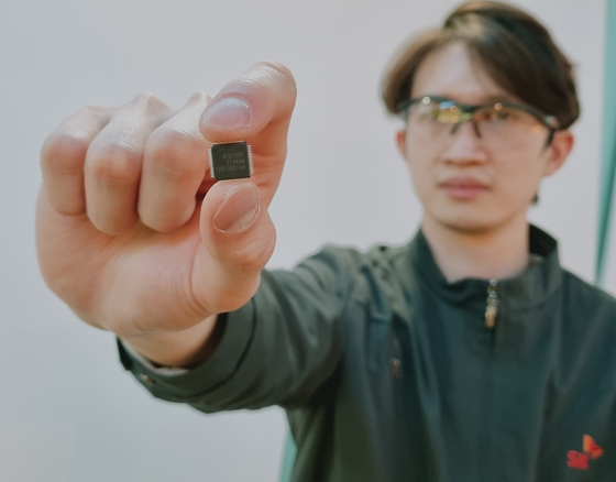 An employee holds a battery management chip jointly developed by SK On and Autosilicon. [SK ON]