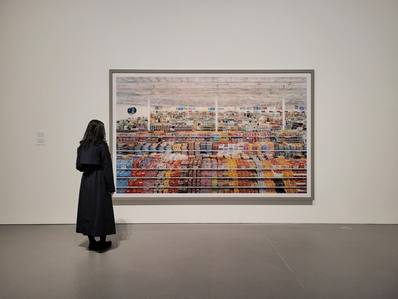 A journalist looks at the 2009 remastered version of “99 Cent” (1999) by Andreas Gursky in a preview of his solo show at Amorepacific Museum of Art (APMA) in Yongsan District, central Seoul last Tuesday. [MOON SO-YOUNG]