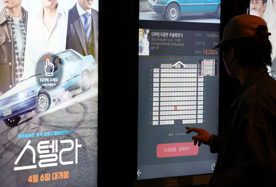 A customer buys a movie ticket at a CGV theater in Seoul on Monday. CGV raised its ticket prices by 1,000 won to 5,000 ($0.80 to $4) won on Monday, marking the multiplex chain's third price hike since the Covid-19 pandemic broke out. The price of regular 2-D movies jumped by 1,000 won to 14,000 won on weekdays and 15,000 won on weekends. [YONHAP]
