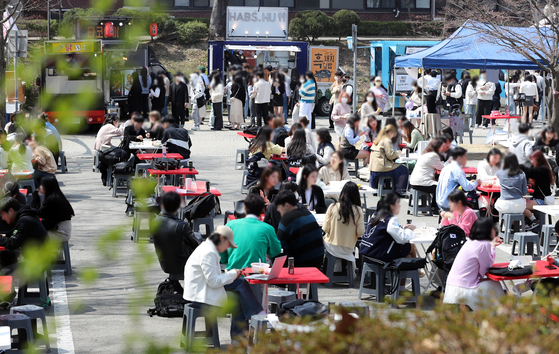 Students at Ajou University in Suwon, Gyeonggi, finally enjoy a spring festival Wednesday after previous years' festivals were canceled due to the pandemic. [YONHAP]