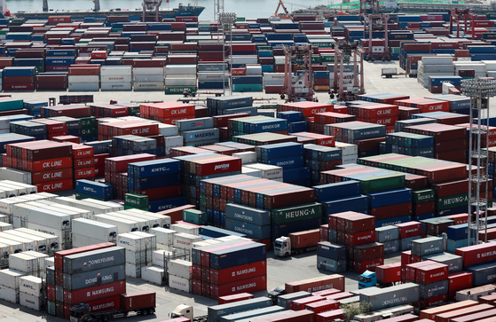 Containers are unloaded at a dock in Busan. [YONHAP]