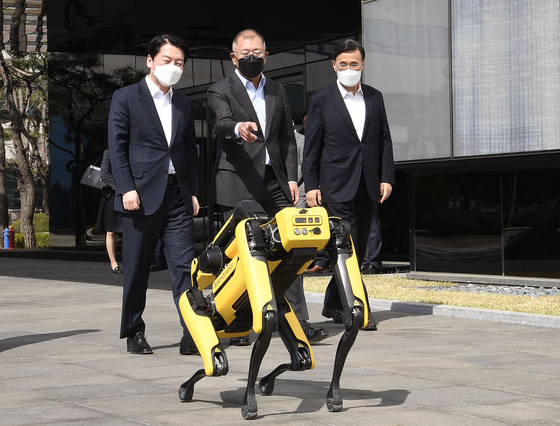 Ahn Cheol-soo, chief of president-elect's transition team, left, and Hyundai Motor Group Chairman Euisun Chung, center, walk with four-legged robot Spot at the auto group's research and development center in Namyang, Gyeonggi on Friday. [HYUNDAI MOTOR]