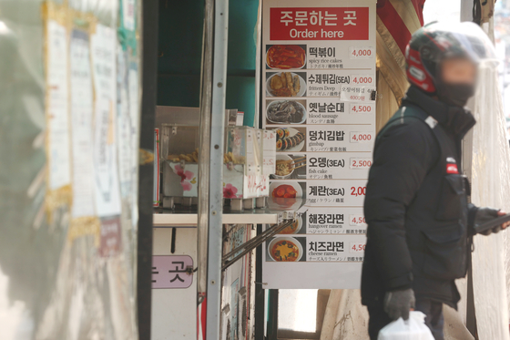 A delivery person taking orders froma tteokbokki store in Seoul on April 5. [YONHAP] 