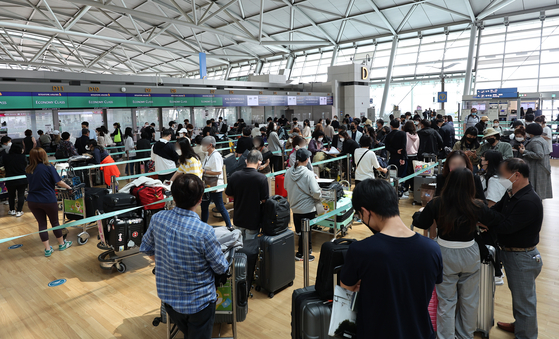 Check-in counters at Incheon International Airport bustle with travelers Tuesday as the government eases Covid-19 rules. [YONHAP]