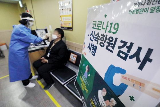 A patient takes a Covid-19 rapid antigen test at a hospital in Dongjak District, southern Seoul, on Monday, as testing centers at public health centers and gu (district) offices stopped offering free rapid antigen tests starting Monday. [NEWS1]