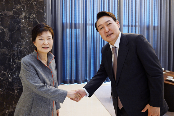 President-elect Yoon Suk-yeol, right, shakes hands with former President Park Geun-hye at Park's residence in Dalseong County, Daegu, Tuesday. [YONHAP]