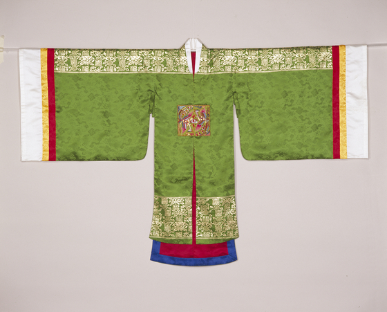 This ceremonial outwear called wonsam was traditionally worn by brides on top of their hanbok. A bride traditionally wears a green jeogori with crimson skirt with a ceremonial wonsam, plus a flower headwear called jokduri. [NATIONAL FOLK MUSEUM OF KOREA]