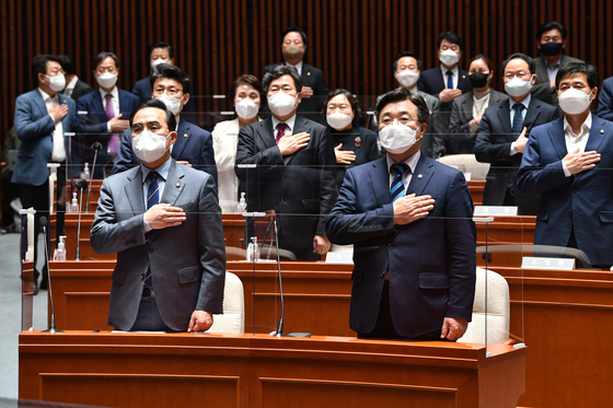 Democratic Party (DP) Chairman Yoon Ho-jung, right, stands next to the party's floor leader Park Hong-keun as DP lawmakers pledge allegiance to the flag at the beginning of Tuesday's meeting to deliberate a controversial bill to abolish the prosecution's investigative powers. [YONHAP]