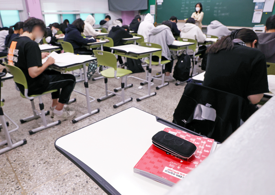 A desk of a Covid-19 confirmed student is empty in a high school classroom in Songpa District, southern Seoul, where a mock college entrance exam was held on Wednesday. [YONHAP]