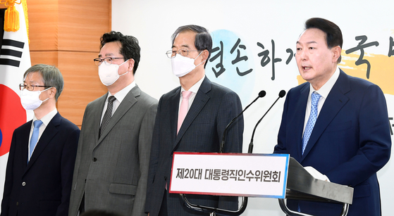 President-elect Yoon Suk-yeol, right, announces Lee Jung-sik, far left, as labor minister and Chung Hwang-keun, second from left, as agriculture minister, completing his first Cabinet Thursday in a press conference at the transition team office in Tongui-dong, central Seoul. [JOINT PRESS CORPS]