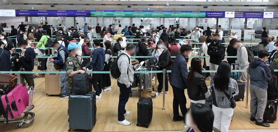 Travelers wait at check-in counters in the departure hall of Incheon International Airport on Thursday following the government's end to a special travel advisory. [NEWS1]