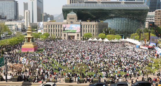 Thousands of Christians gather on Seoul Plaza in front of Seoul City Hall in central Seoul on Sunday to hold an Easter service. The event marked the first time in more than two years that the grass-covered plaza has been filled with people. [YONHAP]