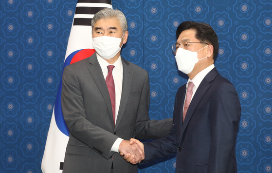U.S. Special Representative for North Korea Sung Kim, left, shakes hands with Noh Kyu-duk, Seoul’s special representative for Korean Peninsula peace and security affairs, at the Foreign Ministry in Jongno District, central Seoul on Monday afternoon. [YONHAP]