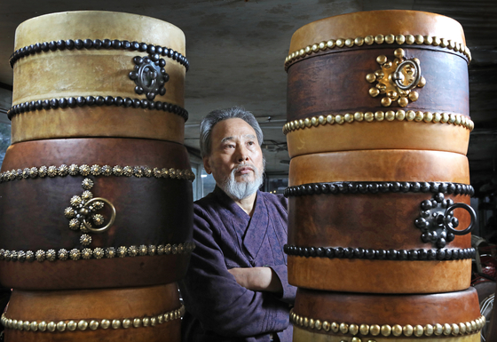 Kim poses in between many of the drums he has made. [PARK SANG-MOON]