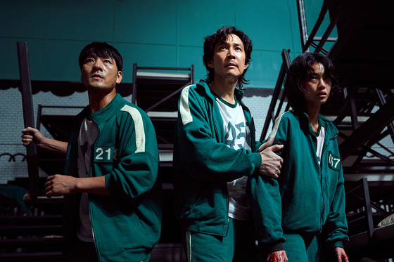 Park, far left, as player No.  218 who participates in a set of deadly children's game to win prize money of 45.6 billion won in Netflix series “Squid Game” (2021) [NETFLIX]
