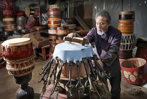Kim Kwan-sik makes drums using bukmaeugi techniques in his studio in Daejeon. [PARK SANG-MOON]