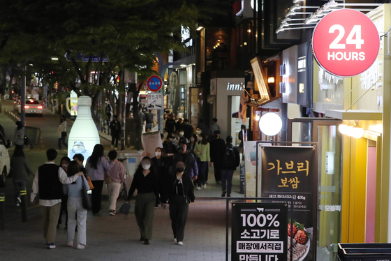 A sign advertises round-the-clock service in Hongdae, western Seoul, on Tuesday night after social distancing measures were lifted in Korea. [NEWS1]