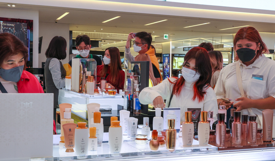 A group of tourists shop for cosmetics at the Shinsegae Duty Free branch in Myeongdong, central Seoul, on April 15. [YONHAP]