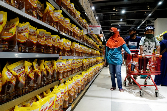 People shop for palm oil at a discount store in Jakarta, Indonesia. [YONHAP/REUTERS]