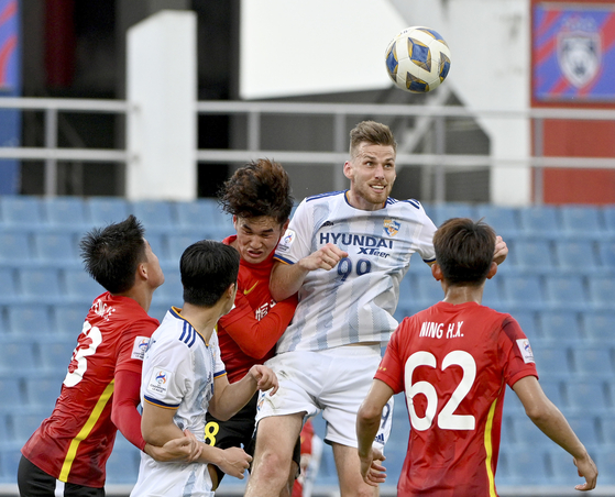 Mark Koszta of Ulsan Hyundai, second from right, goes for a header during the AFC Champions League 2022 Group I match between Guangzhou FC and Ulsan Hyundai in Johor Bahru, Malaysia on Sunday. [XINHUA/YONHAP]