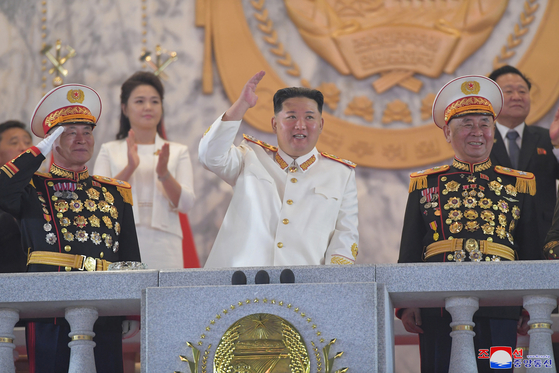Kim Jong-un waves to the crowds at the military parade held at Kim Il Sung Square in Pyongyang, Monday. [YONHAP]