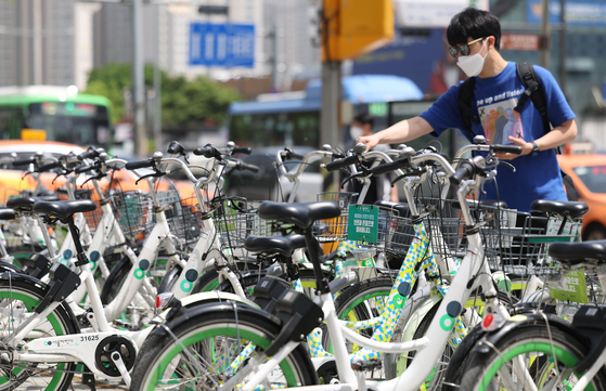 A man borrows a bike from Ttareungi, Seoul's public bicycle service, in Seocho District, southern Seoul, on Wednesday. According to the Seoul city government, the service was used over 100 million times since its launch in December 2015. [YONHAP]