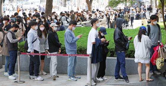 People line up to receive flight ticket coupons in front of the Coffee Bean Gwanghwamun Branch in Jongno District, central Seoul, on Thursday, where Air Seoul International is holding its International Flight Re-Opening Festival. To celebrate the full resumption of international flights, Air Seoul is holding an event to sell round-trip tickets to Guam, Saipan, Da Nang and Boracay at a discount of up to 97 percent for 1,000 customers. [YONHAP]