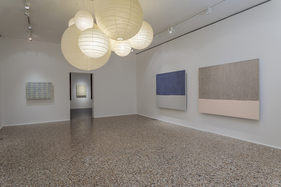 The installation view of the joint exhibition of Danh Vo, Isamu Noguchi and Park Seo-bo. Here shows a room with Park's dansaekhwa pieces on the wall and Noguchi's "Akari" light sculptures on the ceiling. [WHITE CUBE]