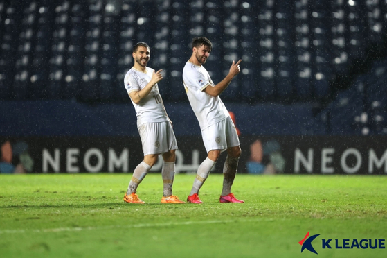 Daegu FC's Zeca, right, celebrates with his teammate after scoring the club's winning goal against Singaporean side Lion City Sailors. Daegu later won the match 2-1 to secure their spot in the knockout round of the AFC Champions League at Buriram Stadium, Thailand on Saturday. [YONHAP]