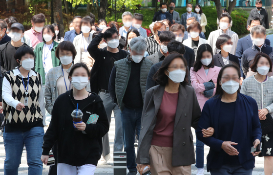 People walk while wearing masks in Daejeon on Monday although the country's outdoor mask mandate was lifted the same day. [NEWS1]