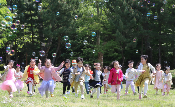 Children frolic maskless in a field at Chonnam National University in Gwangju on Tuesday, two days ahead of Children's Day, May 5. [YONHAP]