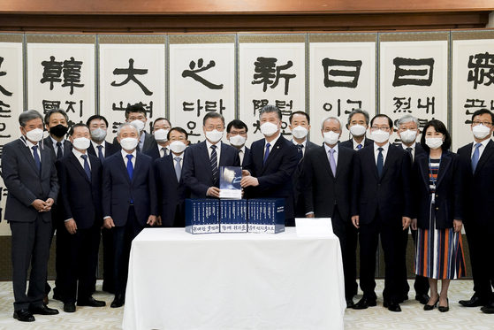 President Moon Jae-in, center left, poses with presidential advisory committee members at an event held at the Blue House on Wednesday to celebrate the publication of a set of books about the Moon government.  [BLUE HOUSE]
