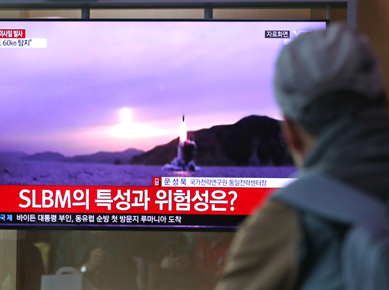 A passerby watches previous reports of an SLBM launch in the waiting room of Seoul Station in Jung District, central Seoul, on Saturday. [NEWS1]