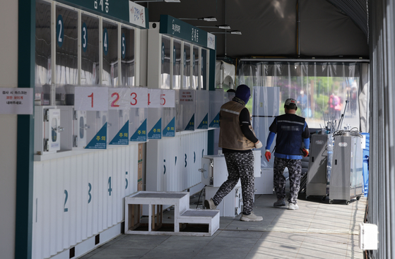 Workers dismantle a test center at Independence Square in Seodaemun District, central Seoul on Monday, when 20,601 new cases were confirmed as the Covid-19 pandemic continues to wane. [YONHAP]