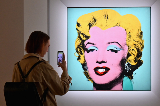 A woman takes a photo of Andy Warhol's "Shot Sage Blue Marilyn" during Christie's 20th and 21st Century Art press preview at Christie's New York in New York City. An iconic portrait of Marilyn Monroe by American pop art visionary Andy Warhol went under the hammer for a record $195 million on Monday at Christie's, becoming the most expensive 20th century artwork ever sold at public auction. [AFP/YONHAP]