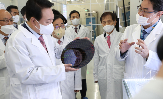 Yoon Suk-yeol, far left, looks at a wafer on April 29 when he visited the National Nanofab Center at KAIST in Daejeon. [JOINT PRESS CORPS] 