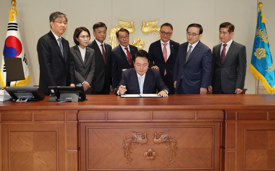 President Yoon Seok-yeol signs his first bill in the new presidential office in Yongsan District, central Seoul, Tuesday, after his inauguration ceremony. [YONHAP]