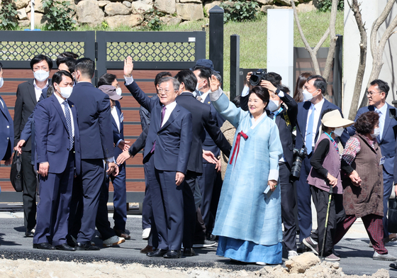 Former President Moon Jae-in, center left, and former first lady Kim Jung-sook, center right, greet a crowd gathered in front of their retirement home in Pyeongsan Village in Yangsan, South Gyeongsang, on Tuesday. [SONG BONG-GEUN] 