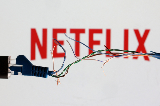 Broken Ethernet cable is seen in front of Netflix logo in this illustration taken March 11, 2022. Netflix and SK Broadband entered into the second phase of the legal battle over the payment of network usage fees. [REUTERS/YONHAP]