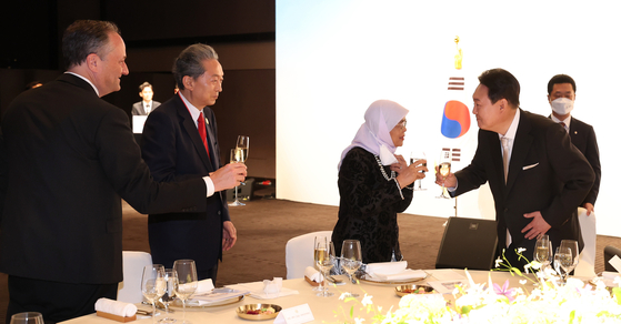 President Yoon Seok-yeol, right, toasts foreign dignitaries including, from left, U.S. second gentleman Douglas Emhoff, former Prime Minister Yukio Hatoyama and Singaporean President Halimah Yacob at his inauguration dinner banquet at The Shilla Seoul in central Seoul Tuesday. [JOINT PRESS CORPS]