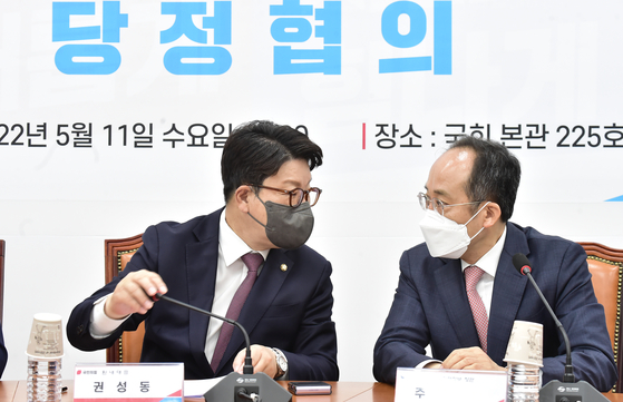 People Power Party floor leader Kwon Seong-dong, left, with Finance Minister Choo Kyoung-ho, during a meeting on the supplementary budget at the National Assembly on Wednesday. The meeting took place just a day after President Yoon Suk-yeol was sworn into office. [YONHAP] 