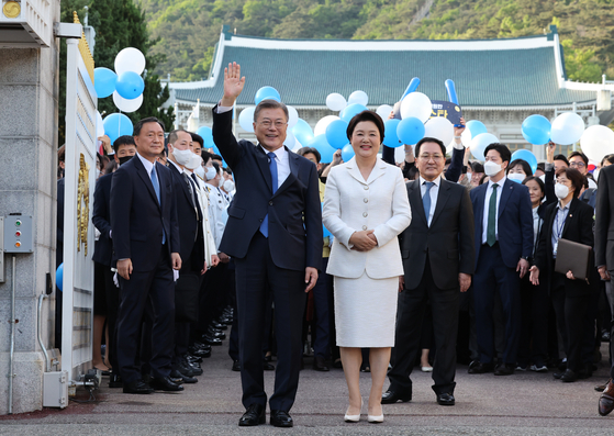 Outgoing President Moon Jae-in, center left, and first lady Kim Jung-sook, are seen off by staffers and ordinary people gathered in the streets in front of the Blue House compound in central Seoul Monday. [YONHAP]