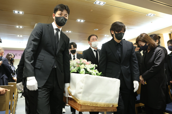 Actors Jung Woo-sung, left, and Seol Kyung-gu, carry late actor Kang Soo-youn's coffin after her funeral on Wednesday. [ILGAN SPORTS]