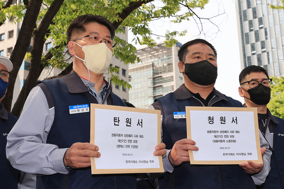 Members of the SsangYong Motor labor union hold up a petition submitted to the Korea Exchange in Yeouido, western Seoul, requesting the exchange operator extend the grace period before declares it delisting. The Korea Exchange has until May 17 to make the final decision. [YONHAP]