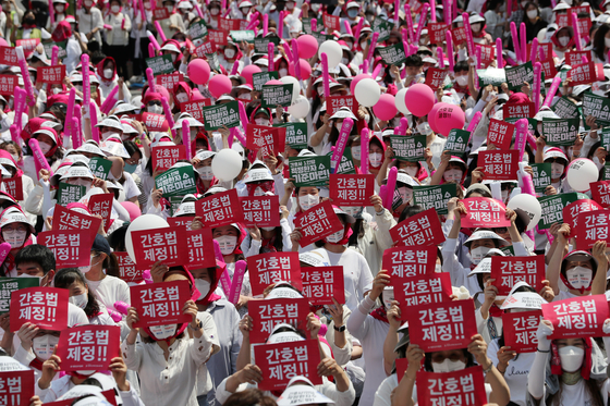 Thousands of nurses hold a rally in front of the Donga Duty Free Store in Jongno District, central Seoul, on Thursday. [NEWS1]