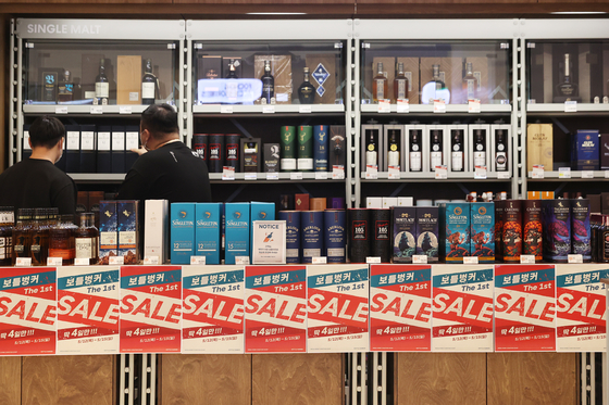 Customers purchase wine from Lotte Mart's wine shop, Bottle Bunker, in Songpa District, southern Seoul on Thursday. Some 1,000 varieties of wine will be on sale with discounts of up to 50 percent until May 15. [YONHAP]